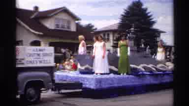 Mabel Minnesota (1969): Women In Dresses Wave On Parade Float With Battleship Then