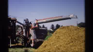 Mabel Minnesota (1969): View Of Grey And Red Thresher Machine On A Sunny Day