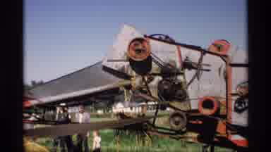 Mabel Minnesota (1969): Several People Standing Around A Hay Baler As It's In
