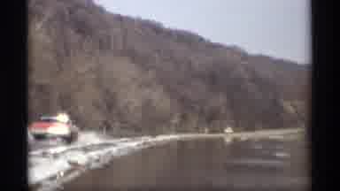 Savage Minnesota (1969): Red Black Vehicle Drives Through Water Caused By Snowmelt