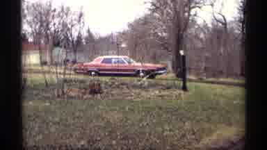 Savage Minnesota (1969): Red Four Door Sedan Rounds Corner On Dirt Road In Front