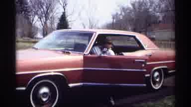 Savage Minnesota (1969): Man In White Shirt Exits Brown Or Red Sedan And Puts On A
