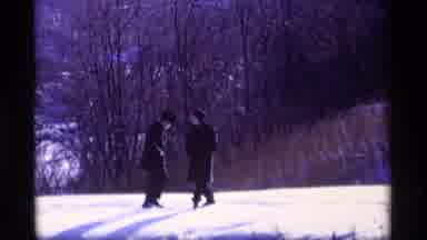 Wisconsin (1969): Two People With Hats Walking Near Woods On The Snow