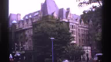 Canada (1974): The Camera Captures The Tall Brown Building And The Trees That