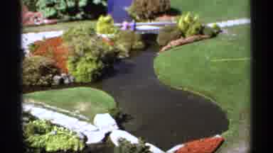 Canada (1974): Two People On A Bridge Overlooking A Garden And Brook
