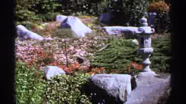 Canada (1974): A Lovely Garden With Rocks Red Flowers And Sculptures On A Sunny