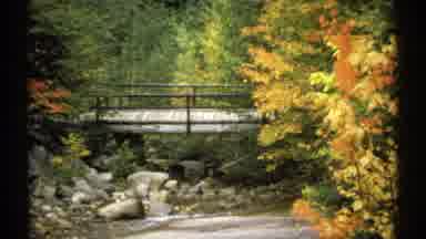 New Hampshire (1971): Person Wearing White Shirt Walks Across Wooden Bridge On A