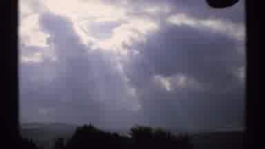 Vermont (1971): View Of White Post Office Sign And Sunlight Shining Through Clouds