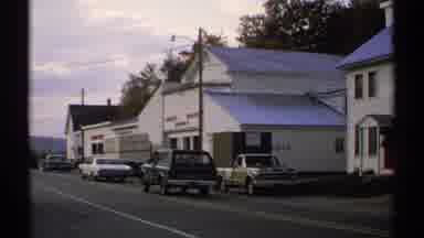Vermont (1971): Cars Driving Down The Road In Front Of Buck's Wife's Market In A