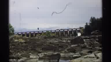 Wisconsin (1971): Large Stones Reflecting Off A Pond Near A Bridge