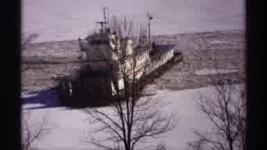 Wisconsin (1971): Large Tug Boat Slowly Moves Out Into River With Snow And Broken