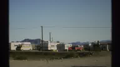 Arizona (1972): Cars Drive In Front Of Rv Park On A Highway