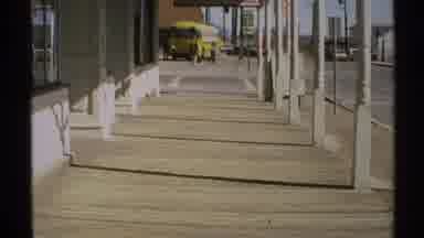Arizona (1972): Looking Down A Wide Sidewalk At A Yellow School Bus And An Old