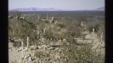 Arizona (1972): Old Tombstones In High Desert Brush Surrounded By Mountain Range