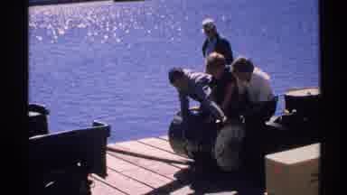 Isle Royale Michigan (1972): Working Men On A Dock Roll A Barrel Scenic Lake