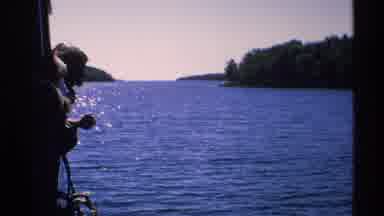 Isle Royale Michigan (1972): Boaters Passing By A Camp Gourd And Campers Waving At