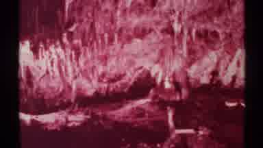 New Mexico (1972): Monochrome Pink Background With Small Human Figures Walking In