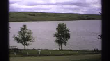 North Dakota (1972): Trees And Parkland In Front Of A River With Rolling Hills In