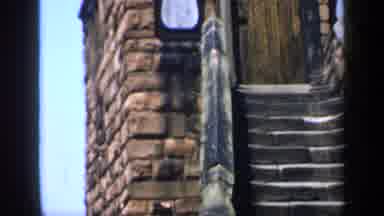 England (1949): Children Looking Up At Tower Stairs And Cars Driving Down A Busy