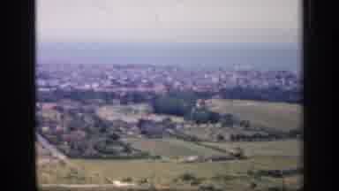 England (1949): Panoramic View Of A Coastal Town With A Hazy Ocean Background And