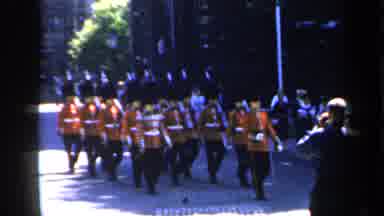 England (1949): British Guards March Together Down The Cobblestone Road As People