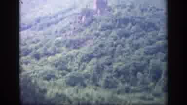 Ireland (1949): View Of Grey Structure Nestled In Green Tree Hillside On A Cloudy