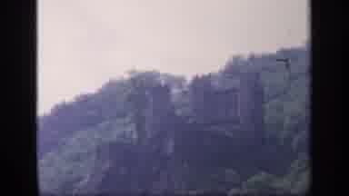 IRELAND-1949: A Dark Castle Overlooking A Jungle On A Hill During The Day