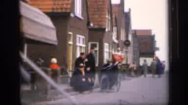 IRELAND-1949: Man Smokes Pipe on Irish Street with Townspeople
