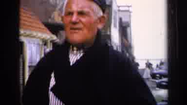 IRELAND-1949: Old Man in Traditional Attire Gestures in Historic Town