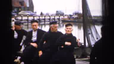 IRELAND-1949: Five Men In Black Fishing Attire Pose On Dock