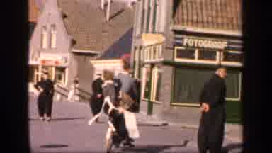 IRELAND-1949: Men in Cassocks and Woman on Bicycle in Sunny Town Street