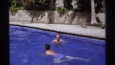 Cabo San Lucas Mexico (1974): Man Wearing Blue Shorts Swims In Pool On A Sunny Day