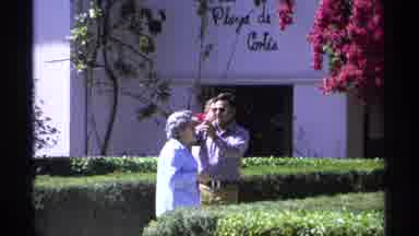 Guaymas Mexico (1975): Man Placing Flower From A Tree In Elderly Woman's Hair At