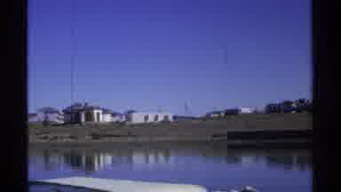 Guaymas Mexico (1975): Grass Buildings Rock Hills Blue Water Boats Docked Daytime