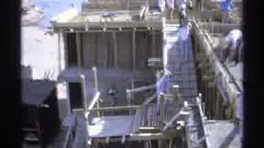 Guaymas Mexico (1975): People Wearing White Pants Carry Grey Buckets Up White Ramp