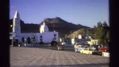 Guaymas Mexico (1975): Vintage Orange Car Driving Through Europe On A Sunny Day