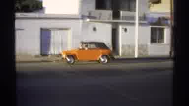 GUAYMAS MEXICO-1975: Orange Volkswagen Thing Driving On Streets