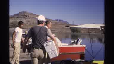Guaymas Mexico (1975): Men Preparing To Board Boat On A Lake Via Dock Carrying