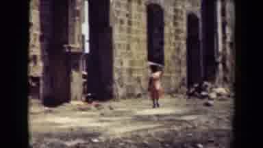 MANILLA PHILIPPINES--194: Lone Person Walks Down The Road By The Tall Stone