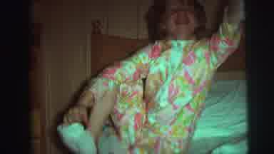Augusta Georgia-usta: Girl in Floral Pajamas Pulls Off Socks on Bed