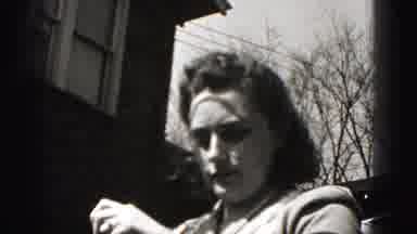 New Cumberland Penn (1946): Woman Wearing Checkered Apron Folds Clothes