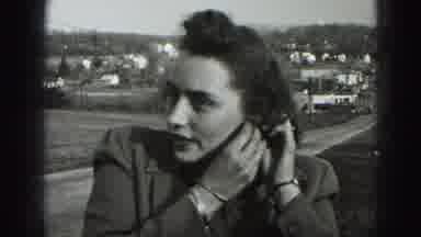 New Cumberland Penn (1946): Woman Adjusting Her Left Earring In A Town With A