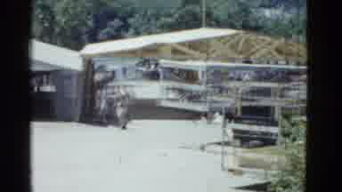 Boston Mass (1951): Man Wearing White Shirt Walks Toward Wooden Shelter Frame On A
