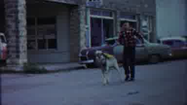 Cheyenne County Kansas (1958): Boy Wearing Red Plaid Shirt Walks Down Street With