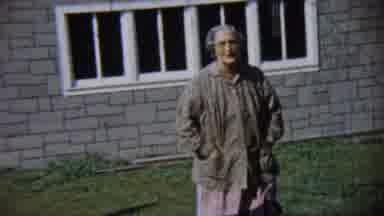 Chadron Nebraska (1959): Older Woman Walking On A Grass Lawn In Front Of A House
