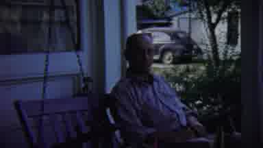 Chadron Nebraska (1959): Man Sitting On A Porch Swing And A Dog Sitting On A Couch