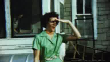 Chadron Nebraska (1959): Woman Wearing Green Dress Walks Backwards From House On A