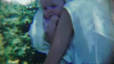 Chadron Nebraska (1959): Woman Wearing White Shirt Holds Baby In White Blanket On