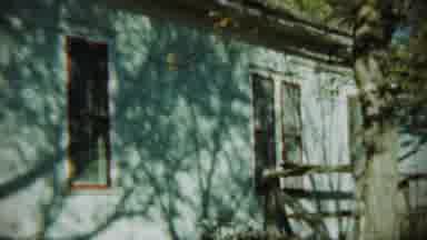 Chadron Nebraska (1959): A Side View Of A White House With Trees Blowing