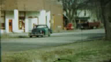 Saint Francis Kansas (1959): Blue Car In Front Of White And Brown Building And